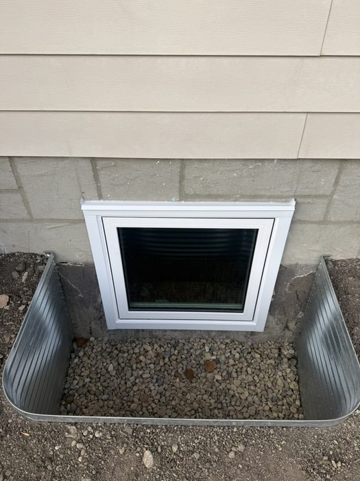 Finished egress casement window with wide galvanized well on Calgary home
