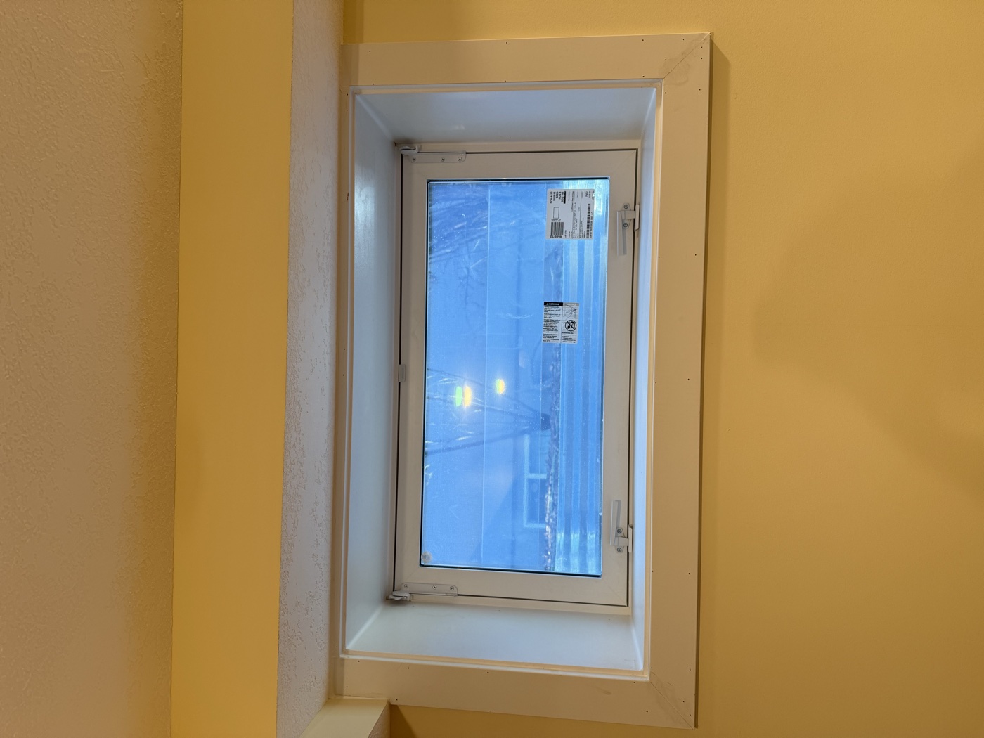Finished interior egress window with white frame and trim — Calgary